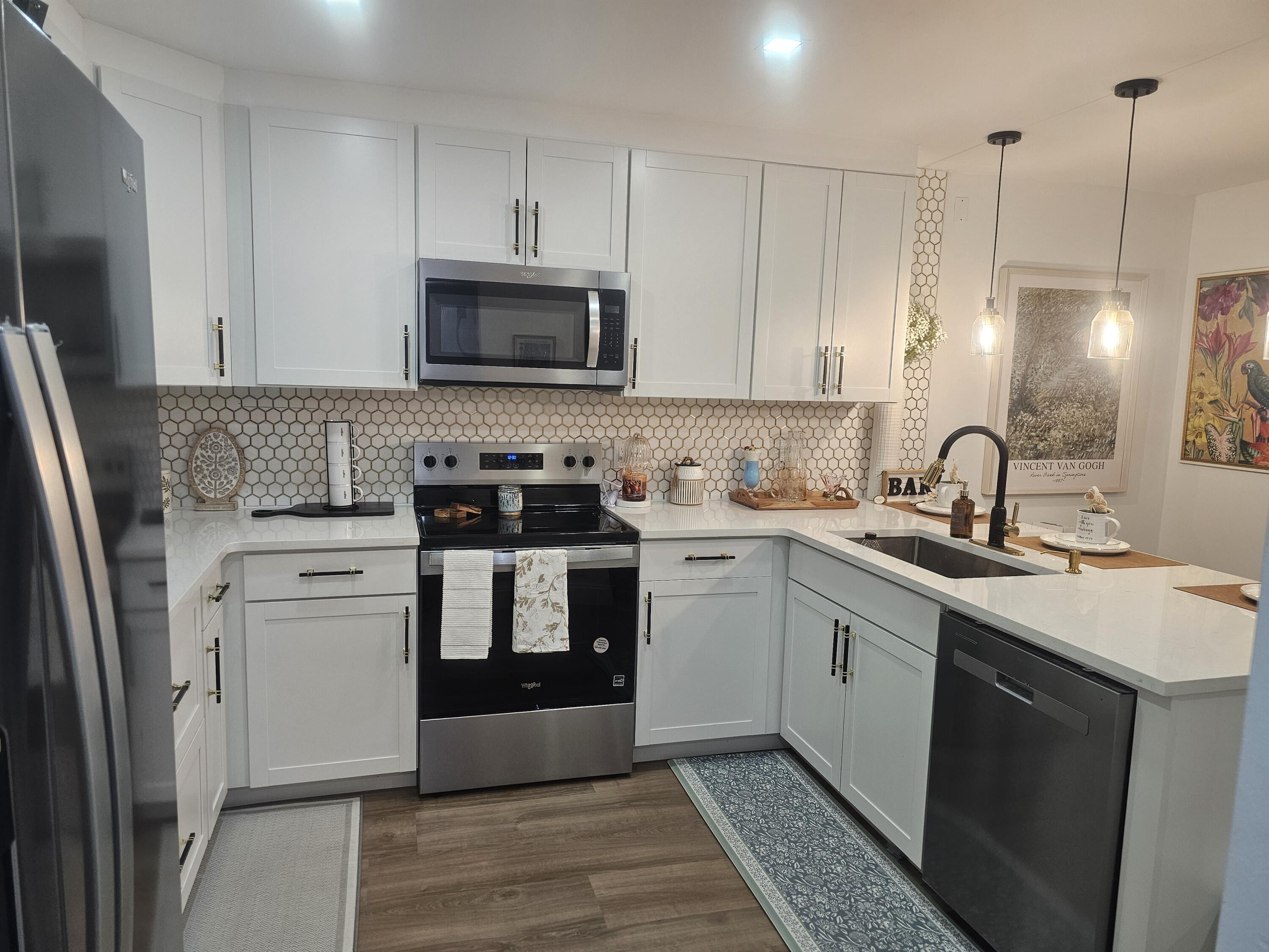 312 Pine Ridge Circle, Unit A2 Greenacres, FL 33463 - Photo 7 of 73 a kitchen with white cabinets sink and stainless steel appliances