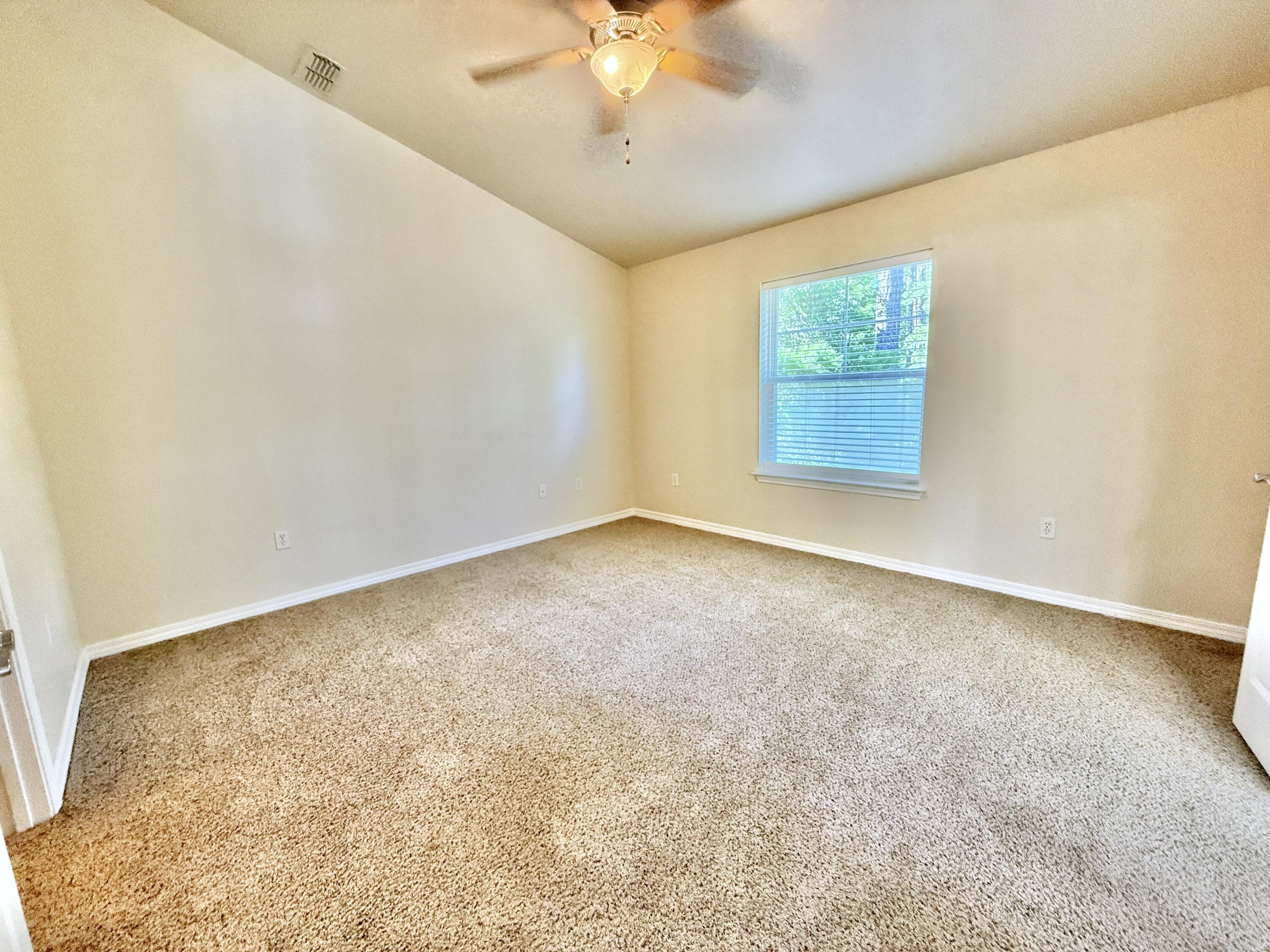 197 Hackberry Way Santa Rosa Beach, FL 32459 - Photo 14 of 26 an empty room with a chandelier fan and windows