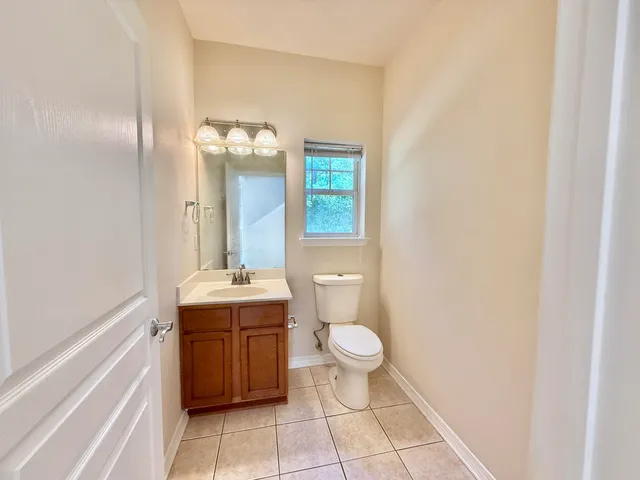 a bathroom with a granite countertop sink a toilet and mirror