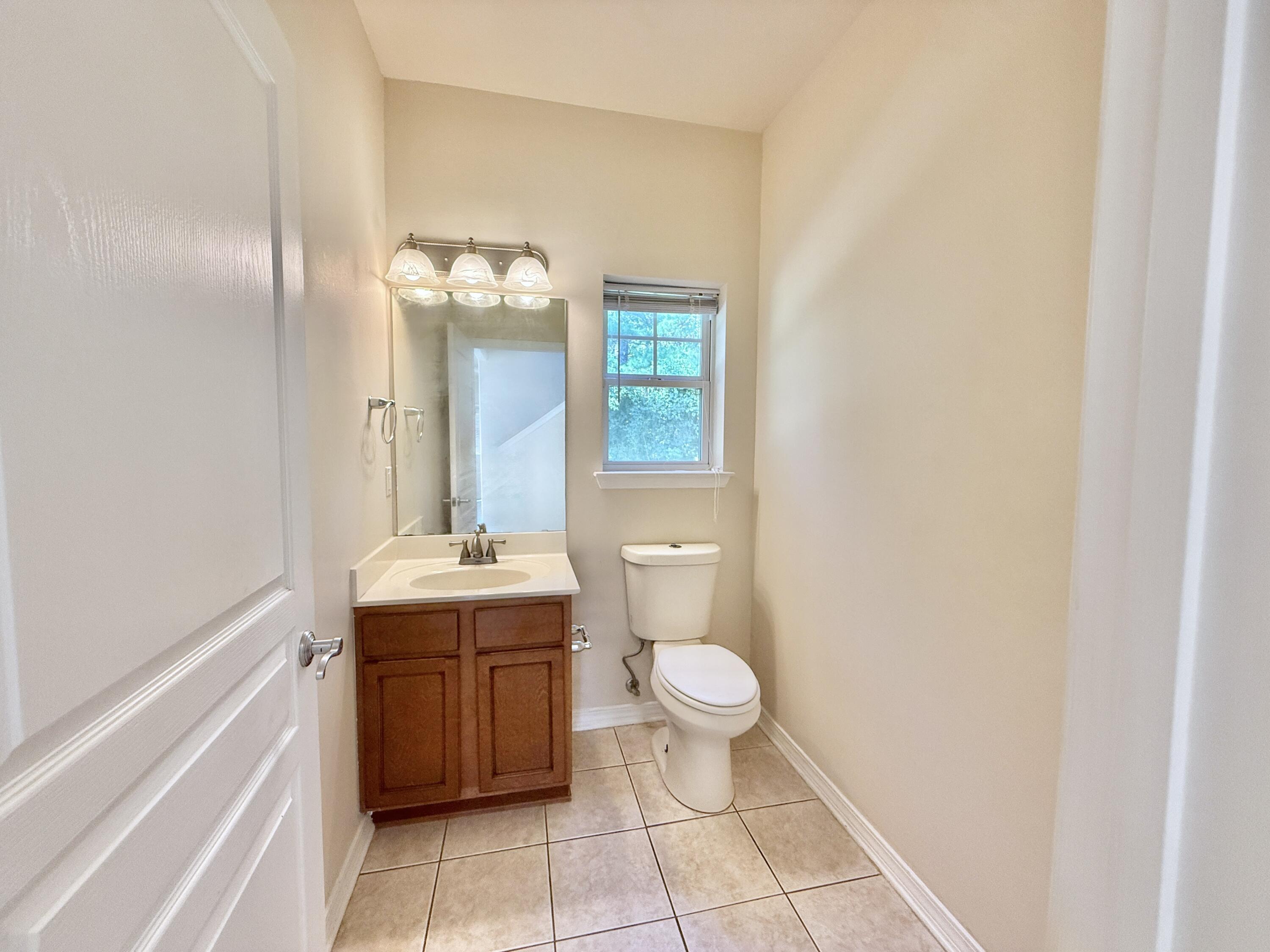 197 Hackberry Way Santa Rosa Beach, FL 32459 - Photo 10 of 26 a bathroom with a granite countertop sink a toilet and mirror
