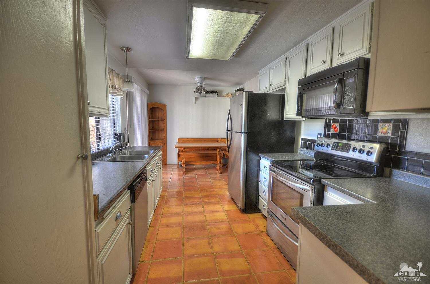 72386 Ridgecrest Lane Palm Desert, CA 92260 - Photo 6 of 38 a kitchen with granite countertop a refrigerator and a stove
