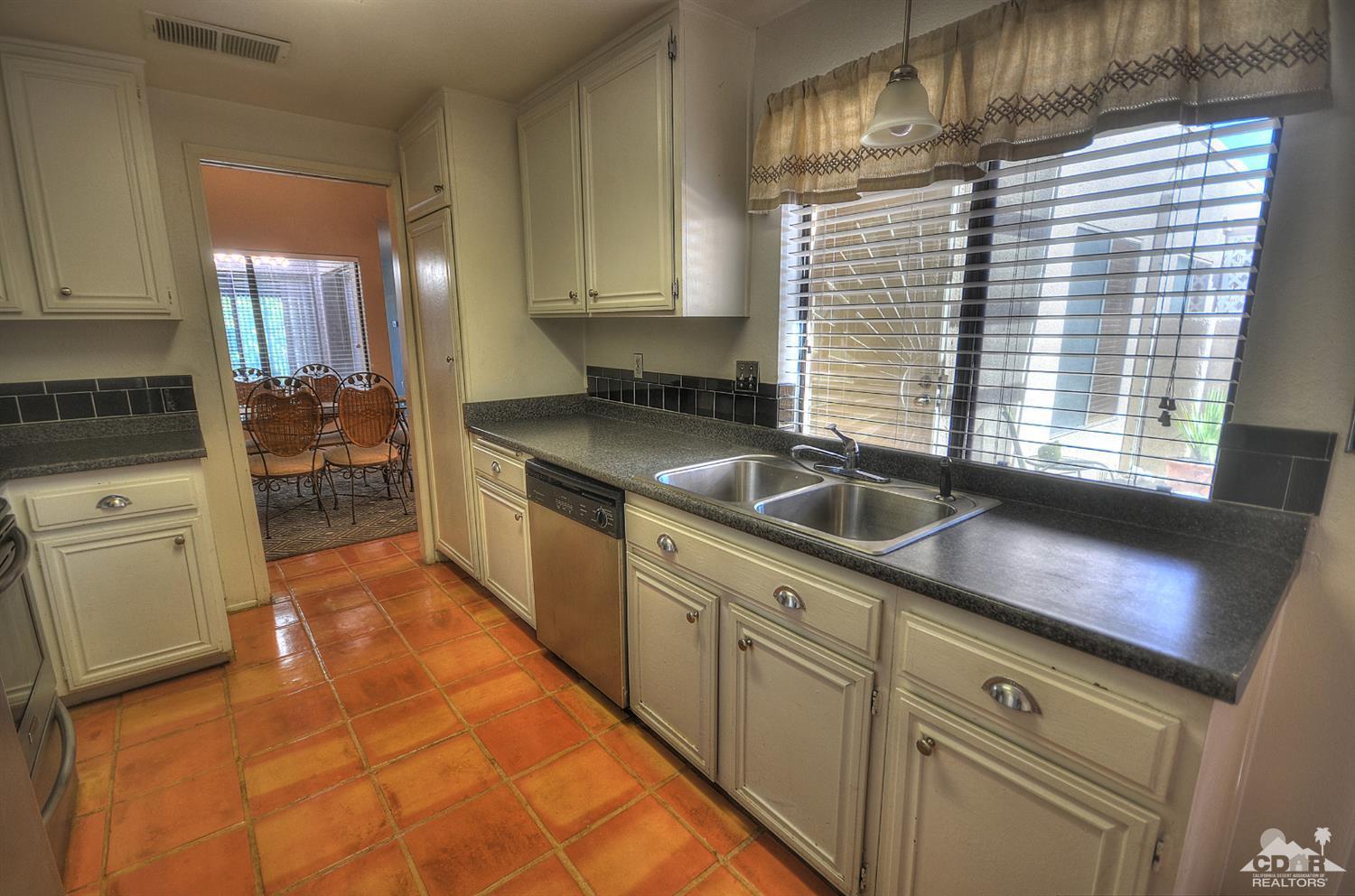 72386 Ridgecrest Lane Palm Desert, CA 92260 - Photo 7 of 38 a kitchen with granite countertop white cabinets and white appliances