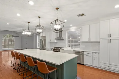 a kitchen with a table chairs sink and cabinets