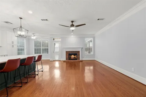 a view of a livingroom with furniture chandelier fan and wooden floor