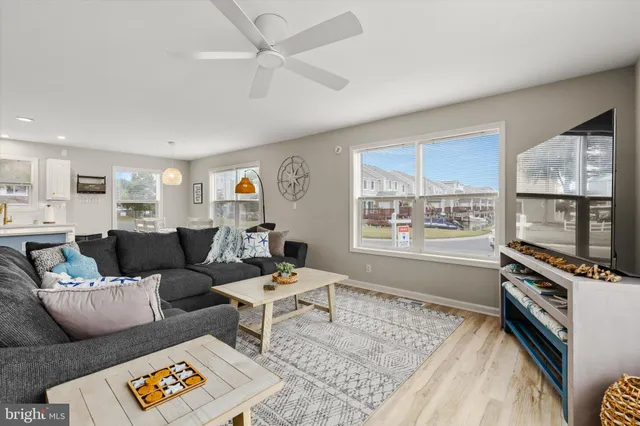 a kitchen with stainless steel appliances granite countertop a stove top oven a sink dishwasher a dining table and chairs with wooden floor