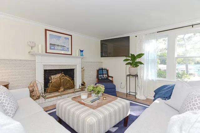 a living room with furniture a large window and a fireplace