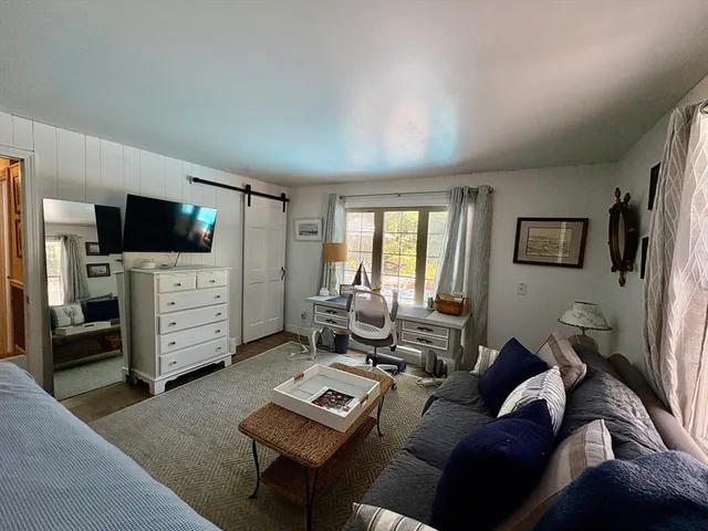 a living room with furniture a flat screen tv and a window