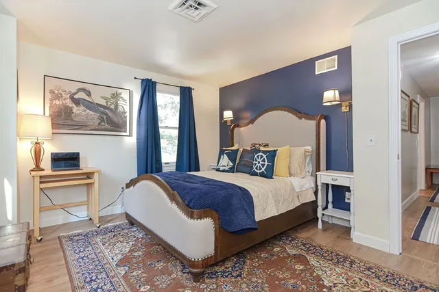 a bed room with a bed and painting on the wall