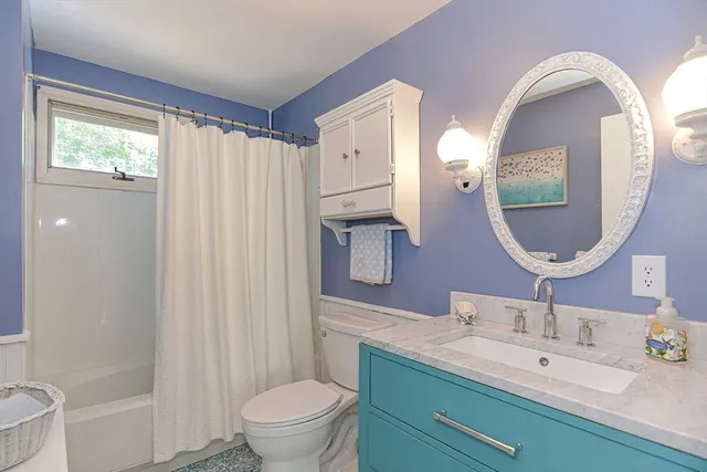 a bathroom with a double vanity sink mirror and toilet