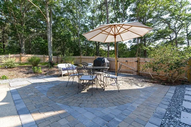 a view of patio with chairs and table under an umbrella