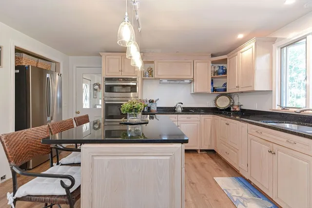 a kitchen with kitchen island granite countertop a sink cabinets and window