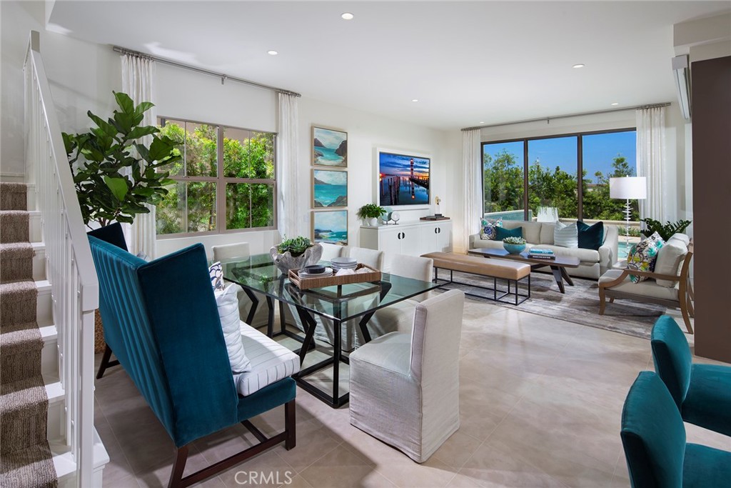 105 Thimbleberry, Unit 76 Irvine, CA 92618 - Photo 3 of 5 a living room with furniture potted plant floor to ceiling windows and a flat screen tv