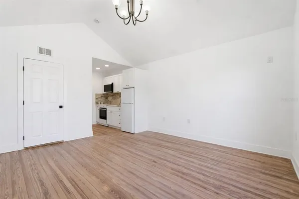 a view of a kitchen with wooden floor and a ceiling fan