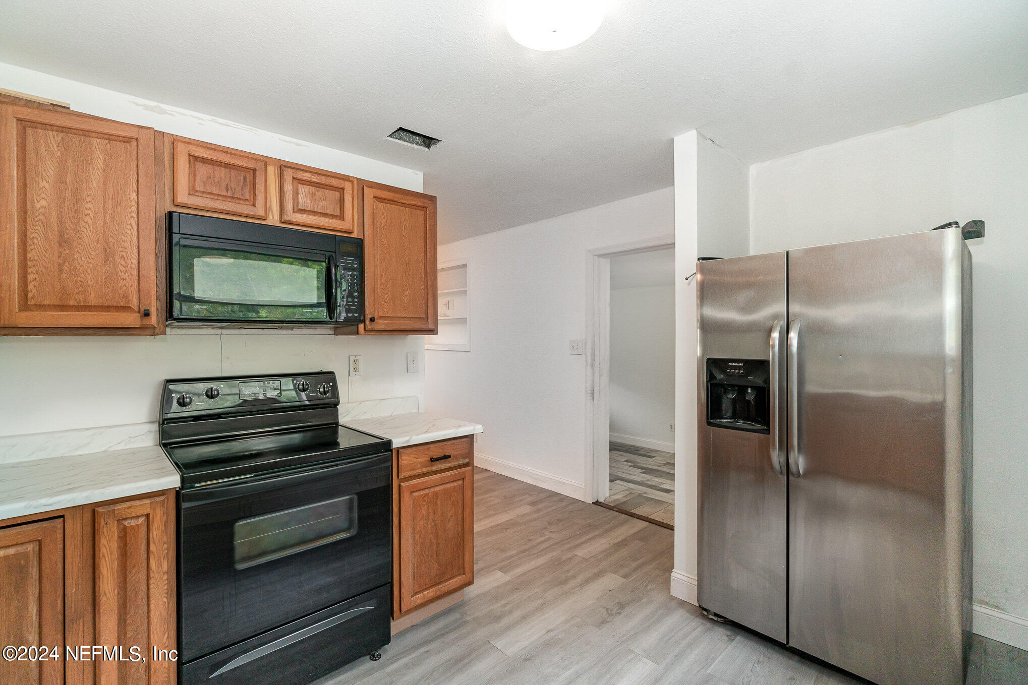 1108 Blair Road Jacksonville, FL 32221 - Photo 11 of 30 a kitchen with granite countertop a refrigerator and a stove top oven