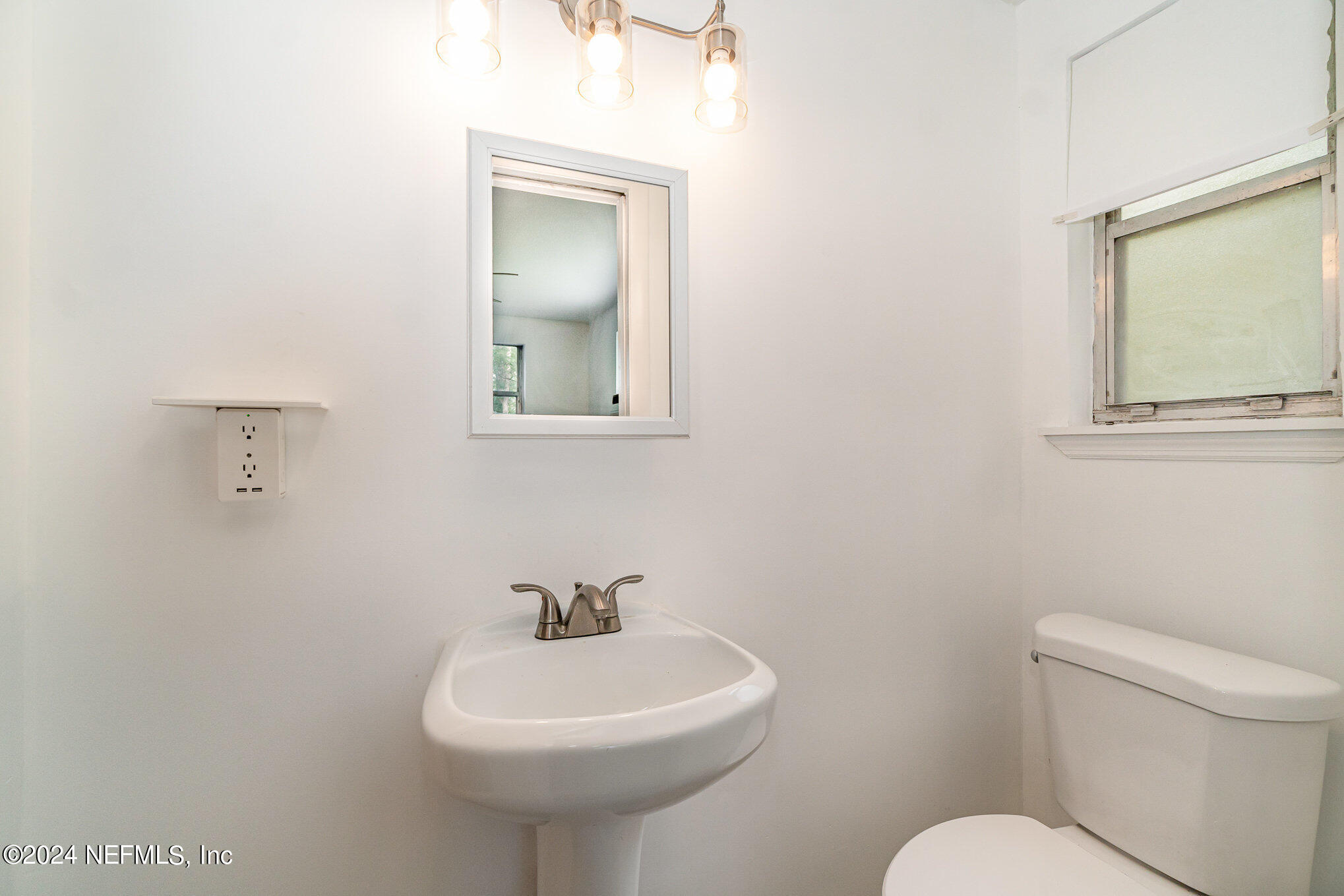 1108 Blair Road Jacksonville, FL 32221 - Photo 15 of 30 a bathroom with a toilet sink and mirror
