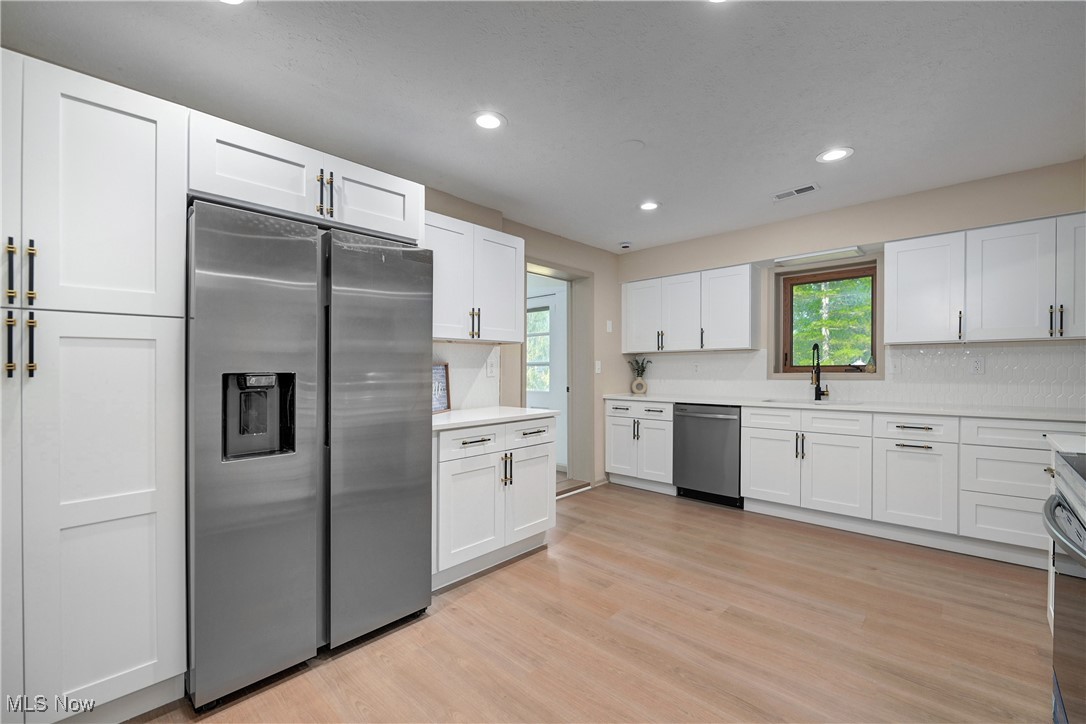 433 Chestnut Road Independence, OH 44131 - Photo 16 of 50 Kitchen with appliances with stainless steel finishes, healthy amount of natural light, light wood-type flooring, recessed lighting, and white cabinets