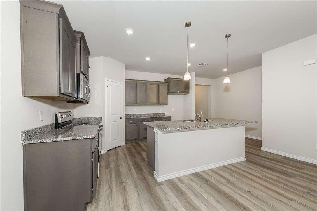 2166 Chief Street Bryan, TX 77807 - Photo 7 of 18 a large white kitchen with a sink a refrigerator and a stove top oven