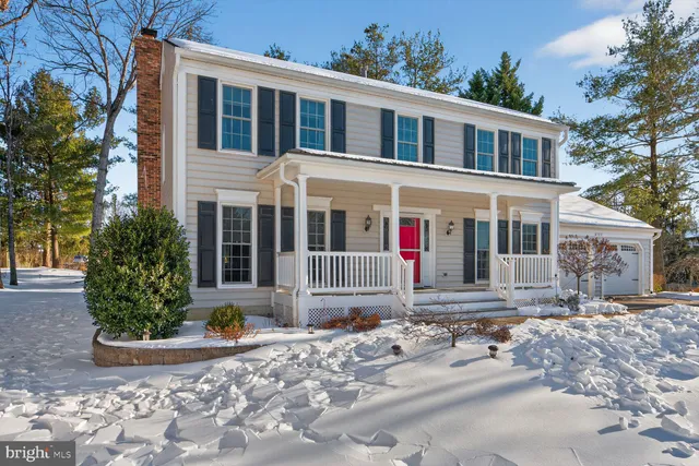 a front view of a house with a yard and trees around