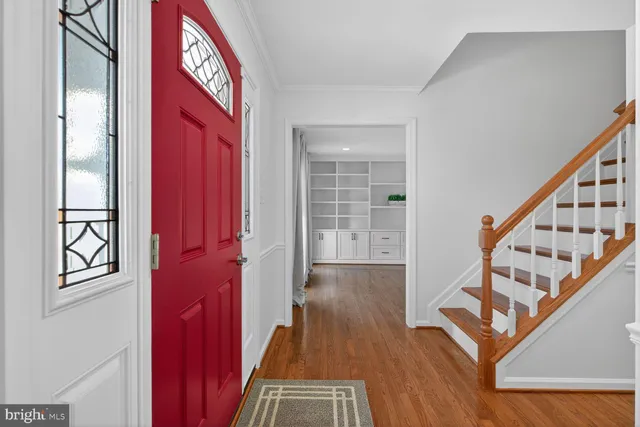 a view of a hallway with wooden floor and staircase
