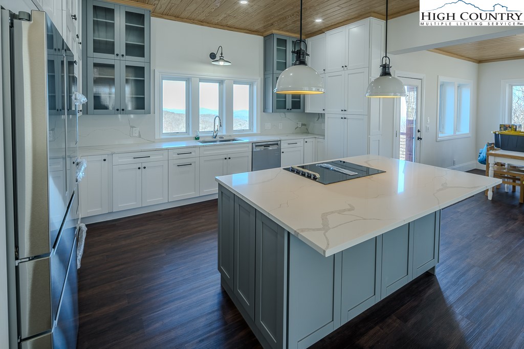 330 North Pinnacle Ridge Road Beech Mountain, NC 28604 - Photo 13 of 38 a kitchen with a stove a refrigerator and wooden cabinets