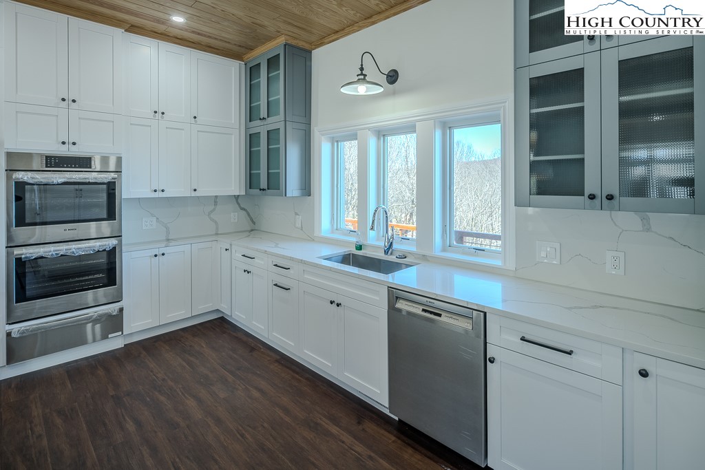 330 North Pinnacle Ridge Road Beech Mountain, NC 28604 - Photo 18 of 38 a kitchen with granite countertop white cabinets and white appliances