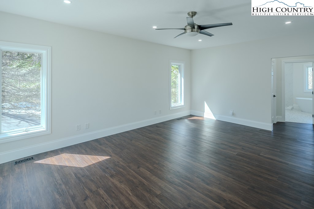 330 North Pinnacle Ridge Road Beech Mountain, NC 28604 - Photo 24 of 38 an empty room with wooden floor chandelier fan and windows