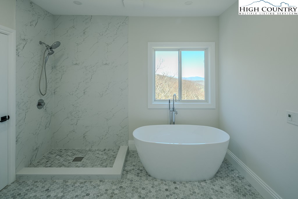 330 North Pinnacle Ridge Road Beech Mountain, NC 28604 - Photo 25 of 38 a white bath tub sitting in a bathroom next to a window