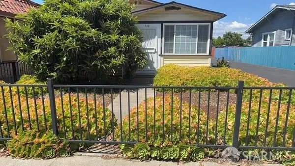 a view of a house with a large window and plants