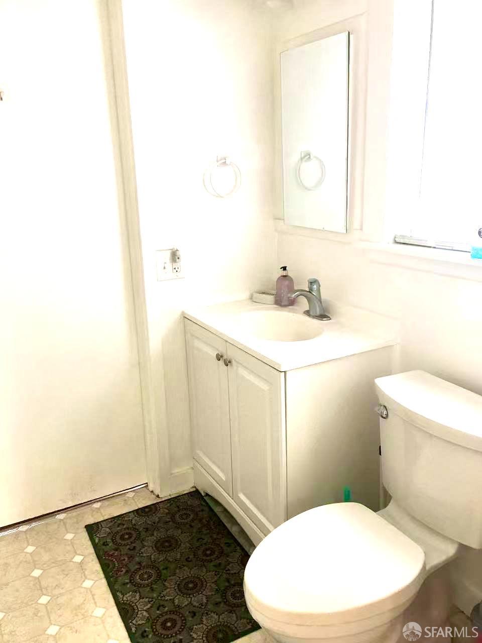 550 A Street Hayward, CA 94541 - Photo 10 of 14 a bathroom with a sink a toilet a mirror and vanity