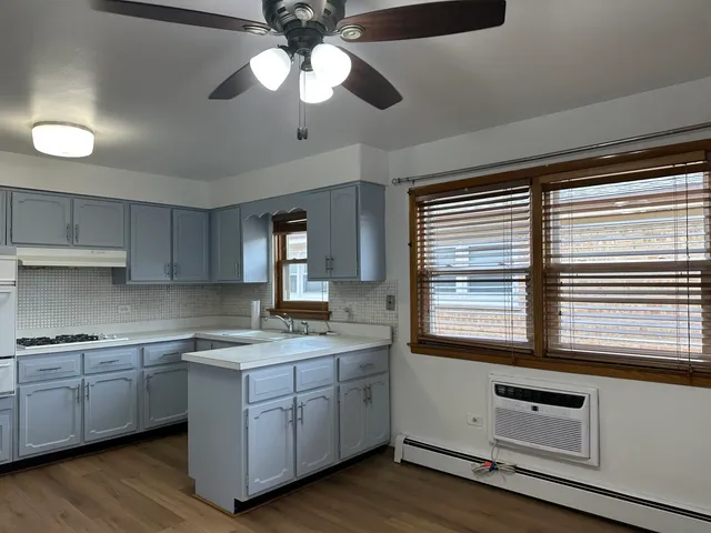 a kitchen with a refrigerator and a stove top oven