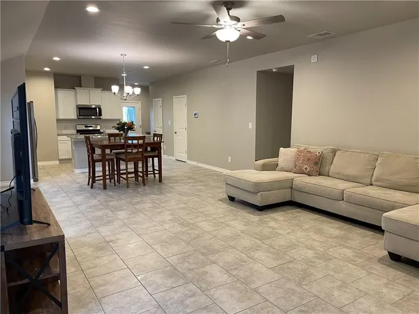 a living room with furniture a dining table and kitchen view