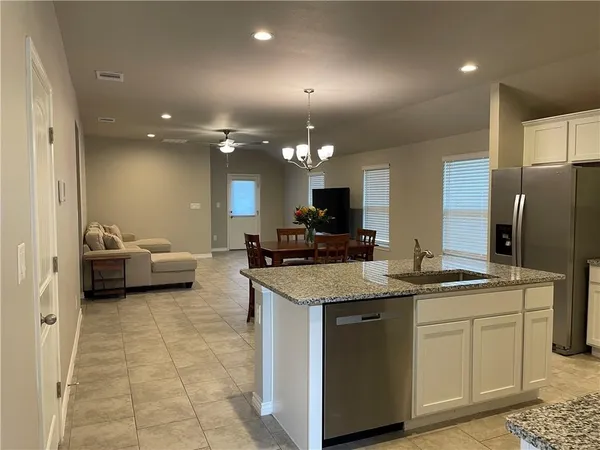 a kitchen with a sink stainless steel appliances and white cabinets