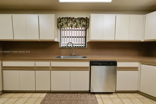 a kitchen with white cabinets and sink