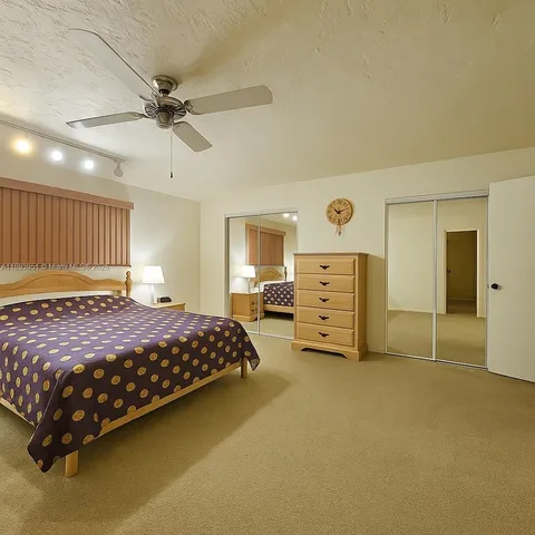 a bedroom with a bed and a ceiling fan