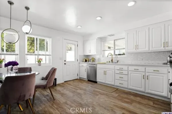 a kitchen with cabinets table and chairs