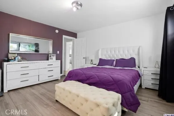 a bedroom with a bed and a dresser in it