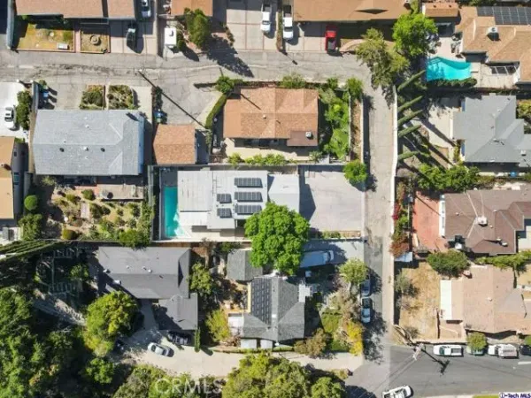 an aerial view of residential houses with outdoor space and trees
