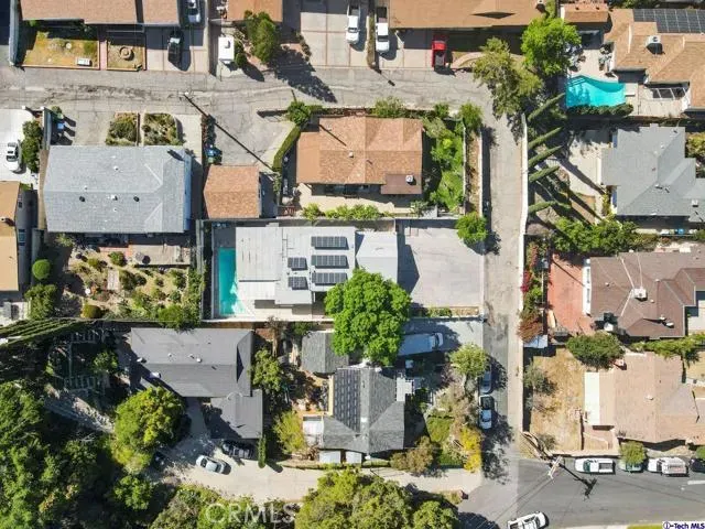 an aerial view of residential houses with outdoor space and trees