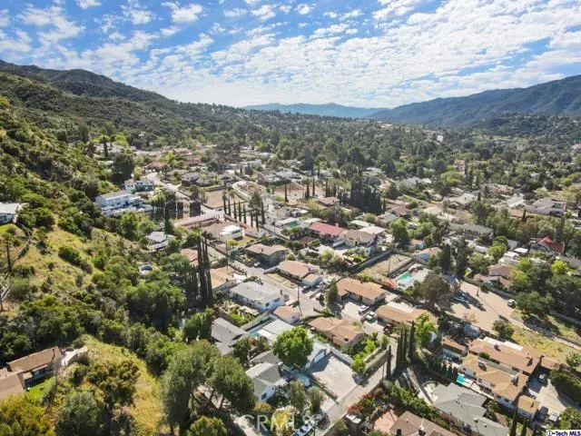 an aerial view of residential houses with outdoor space and trees