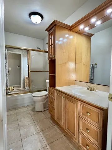 a bathroom with a granite countertop sink a toilet and shower