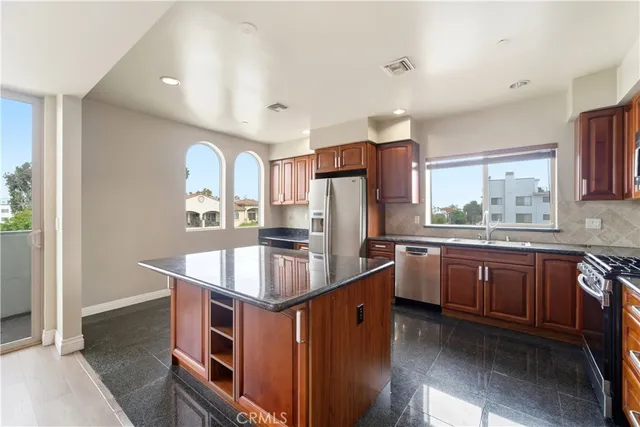 a kitchen with stainless steel appliances granite countertop a sink stove and refrigerator