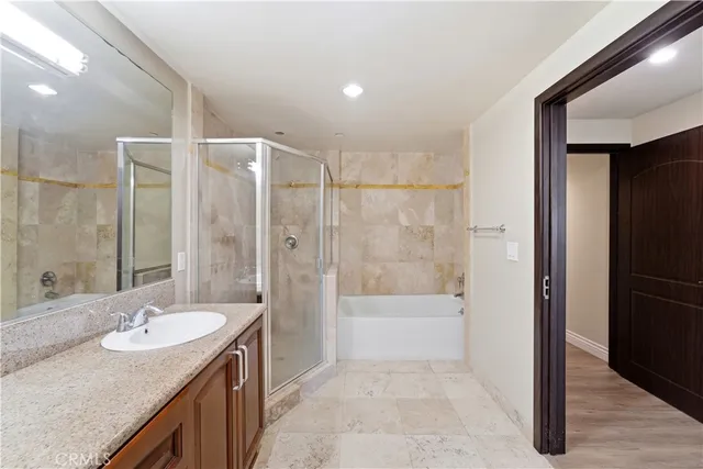 a bathroom with a granite countertop sink a mirror and a bathtub