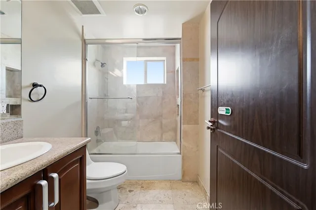 a bathroom with a granite countertop sink toilet and shower