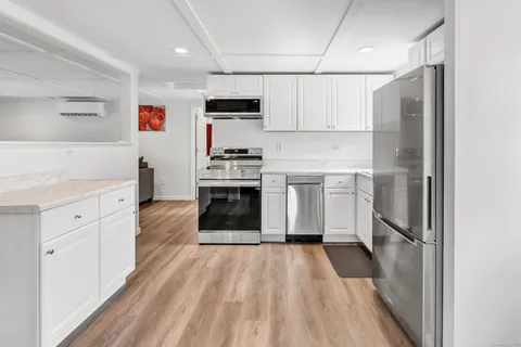 a kitchen with stainless steel appliances a refrigerator sink and cabinets