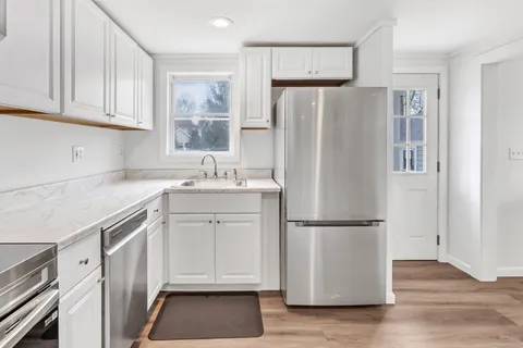 a kitchen with a refrigerator a sink and cabinets