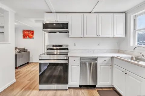 a kitchen with stainless steel appliances granite countertop a stove a sink and a microwave