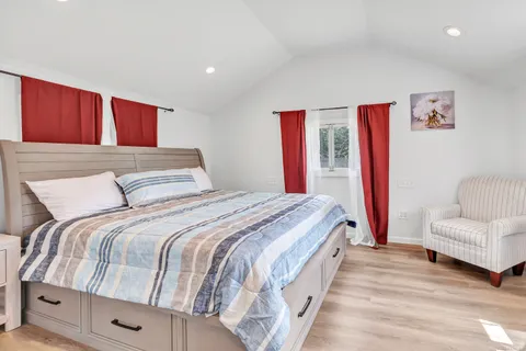 a bedroom with a large bed and a chandelier