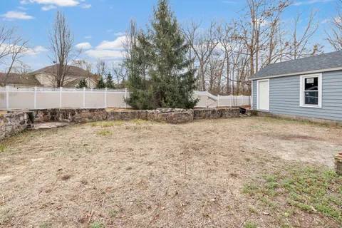 a view of house with backyard and trees