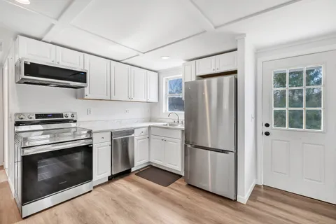 a kitchen with stainless steel appliances a refrigerator stove and microwave