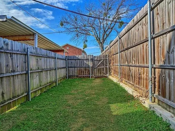 a view of yard with wooden fence and trees